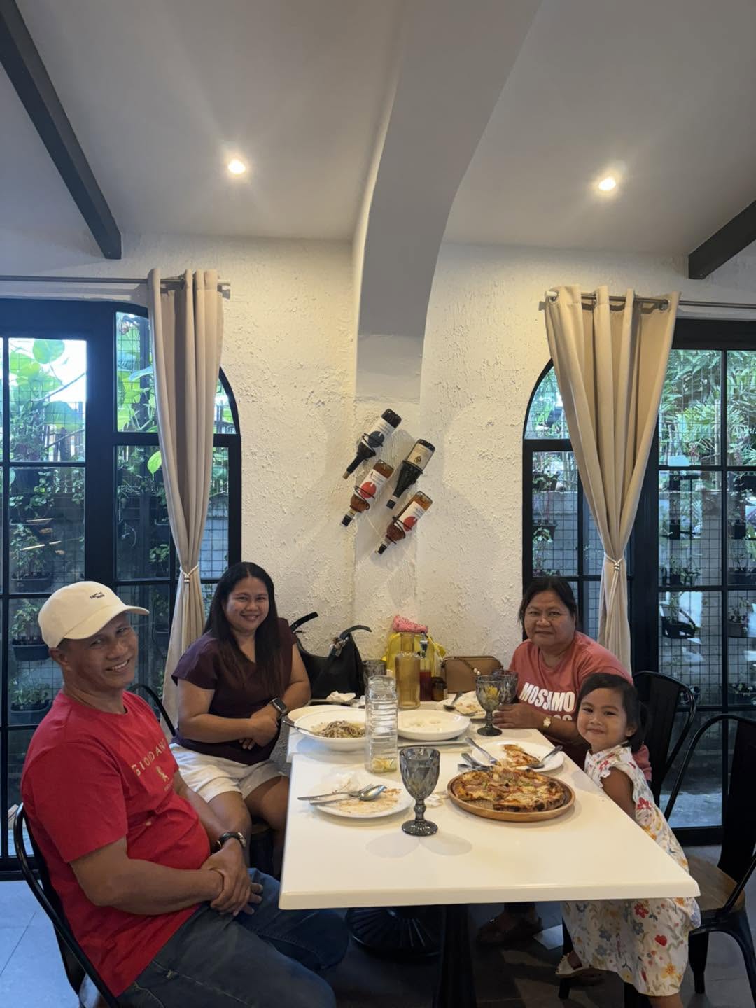 Guests smiling around their dining table at Red Tomato Resto Farm